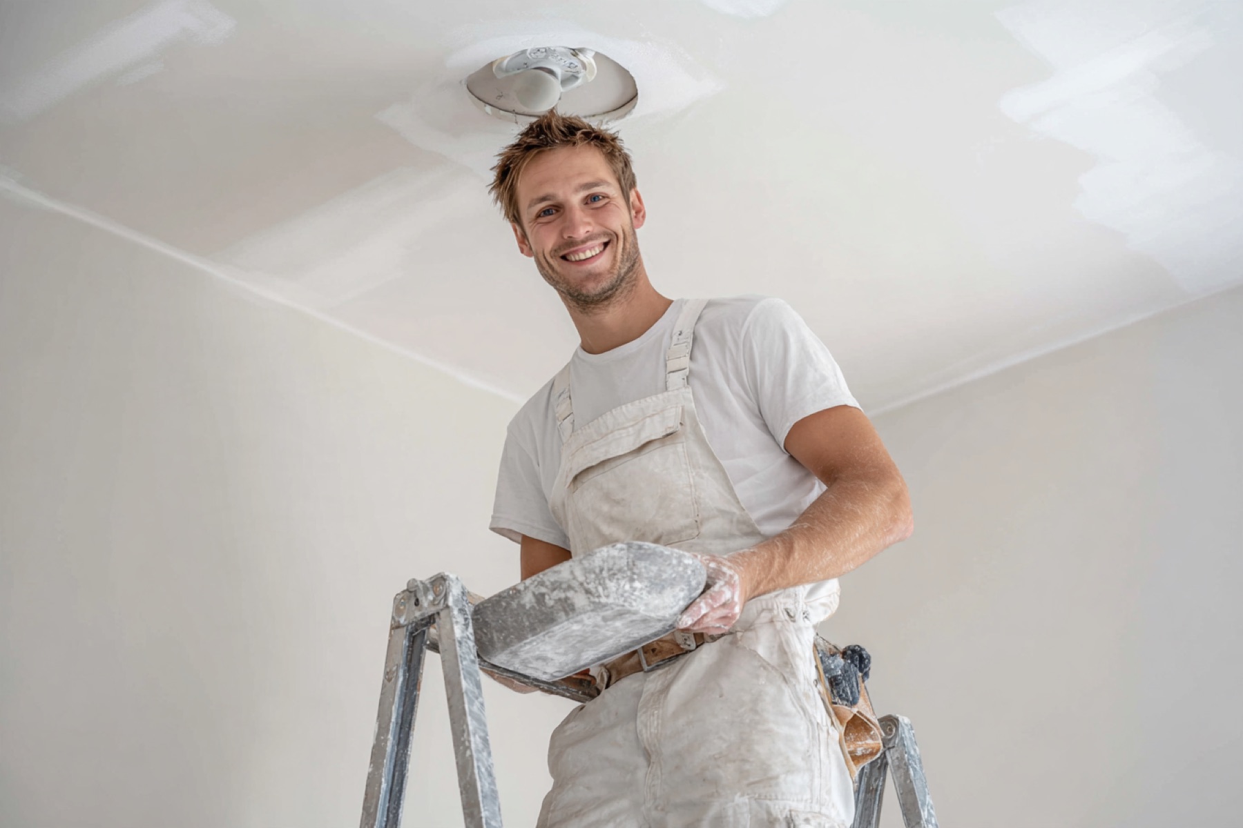 Stukadoor werkt een plafond glad af