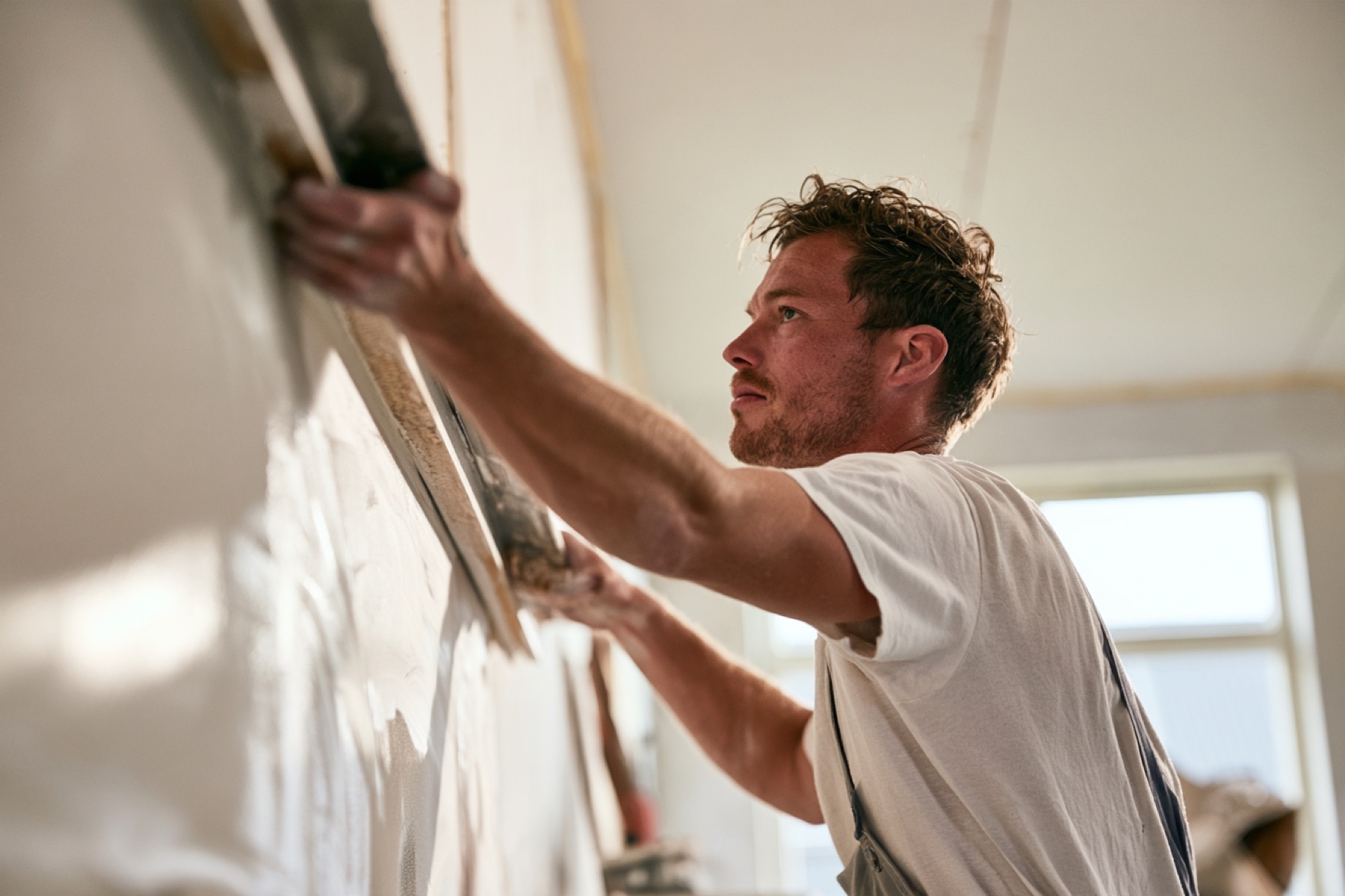 Stukadoor trekt een wand strak met de rei